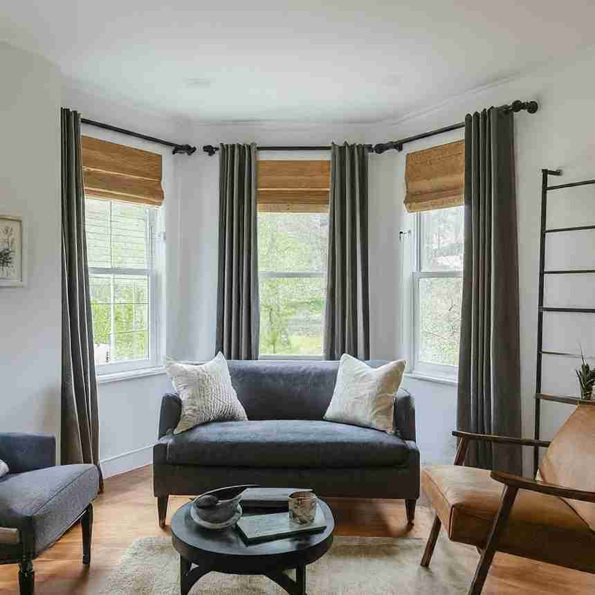 A contemporary living room showcasing a couch, chair, and modern window treatment ideas, creating an inviting atmosphere.